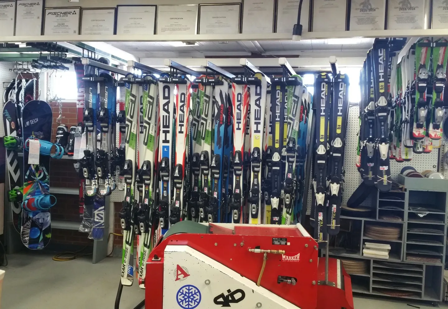 A red cart with skis on it in front of a rack.