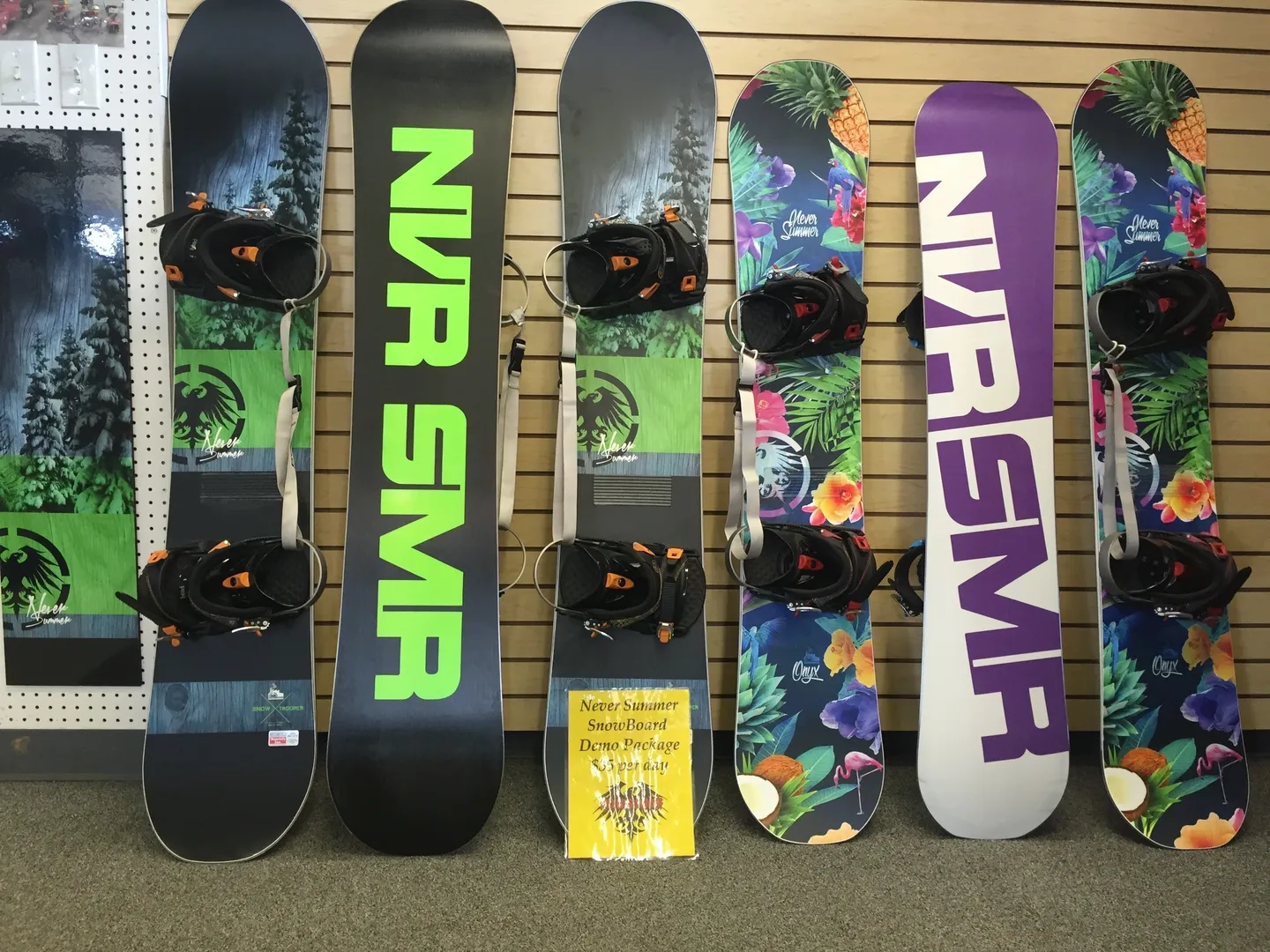 A row of snowboards are lined up against the wall.
